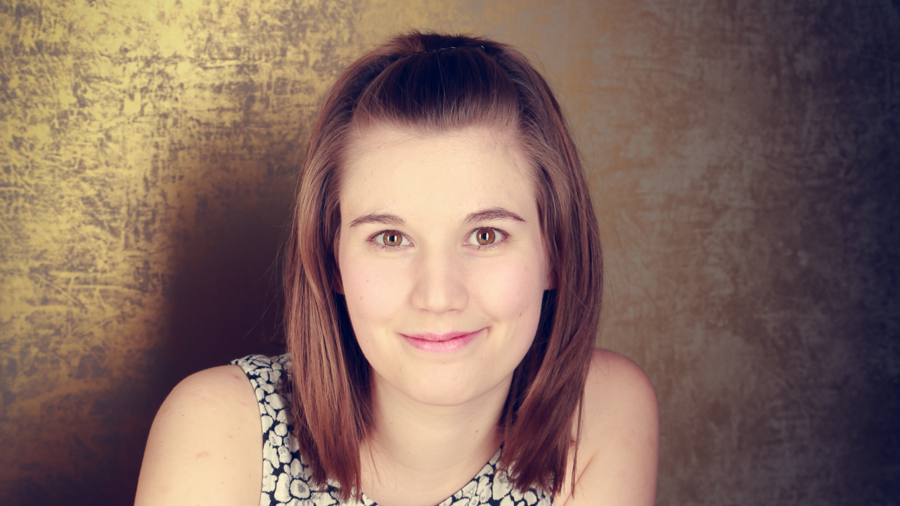 Annika, die Schlaumeierin, vor einer goldenen Wand